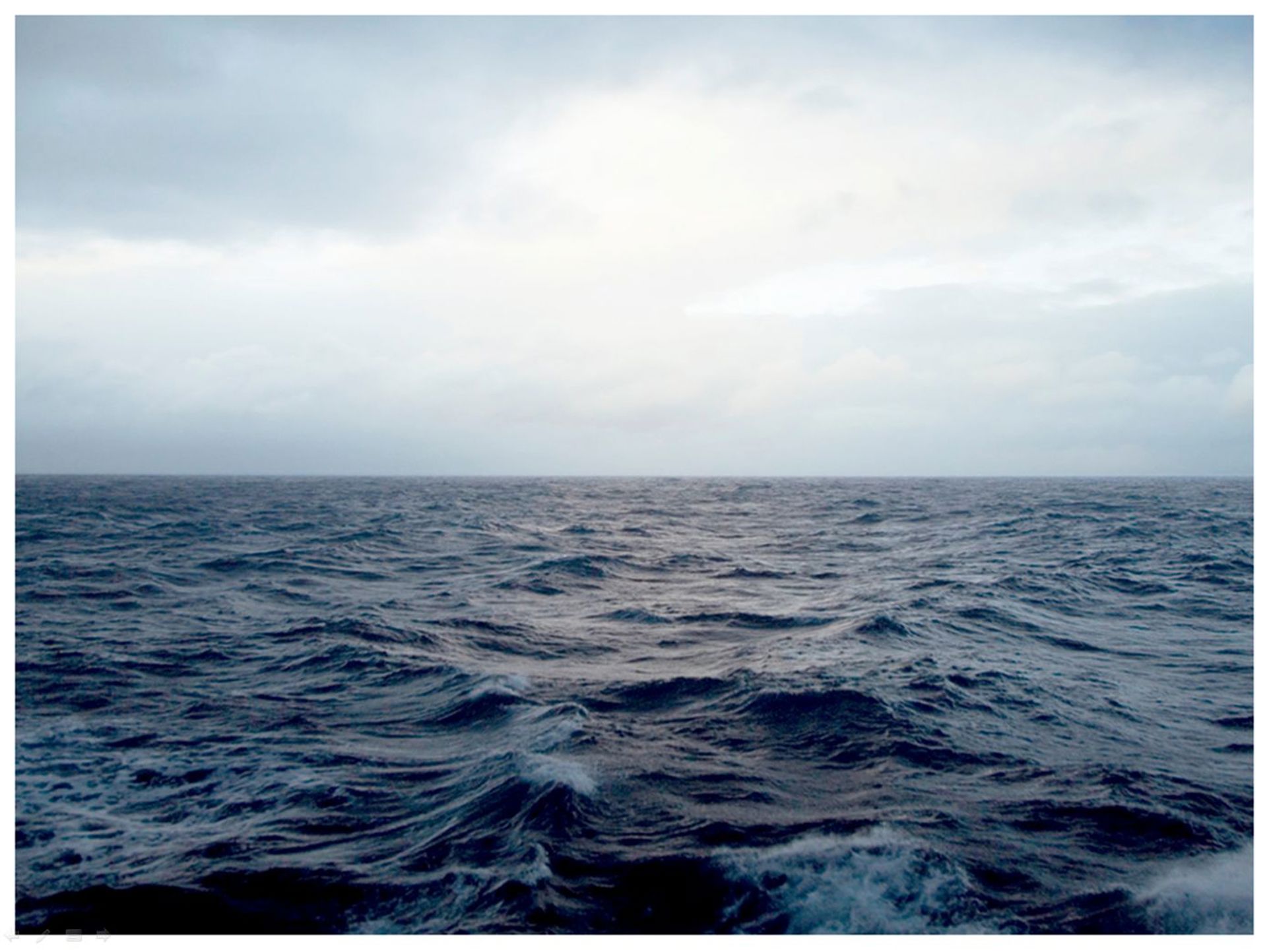 Illustrasjonsfoto: sjø med skummende topper mot en kald gråblå himmel 