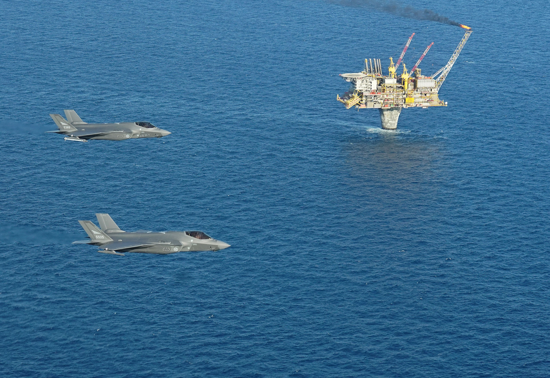 alt="Two F-35As from the Air Force are pictured here flying over an oil platform. Photo: Norwegian Armed Forces "