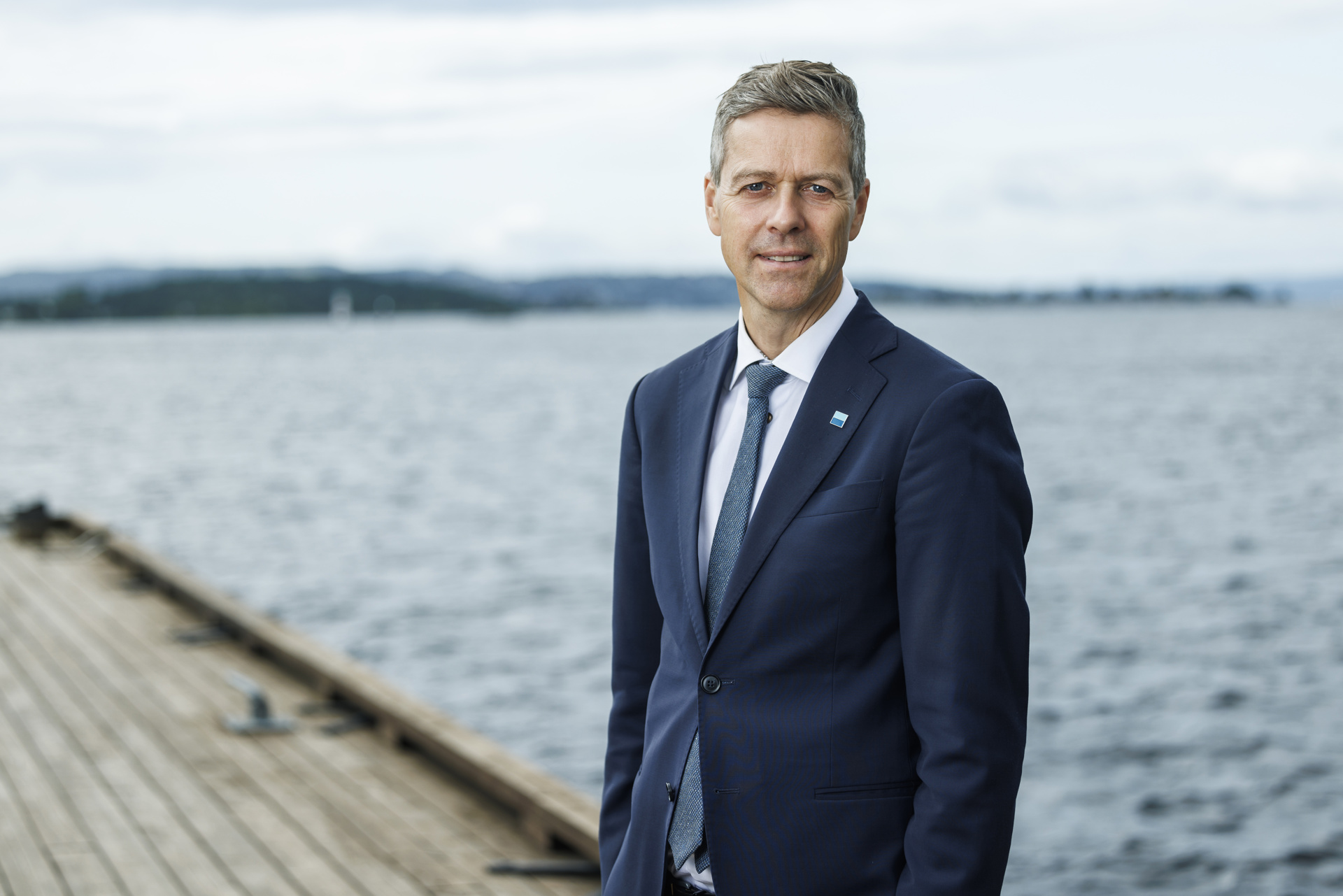 Knut Arild Hareide iført dress på brygga med sjø i bakgrunnen