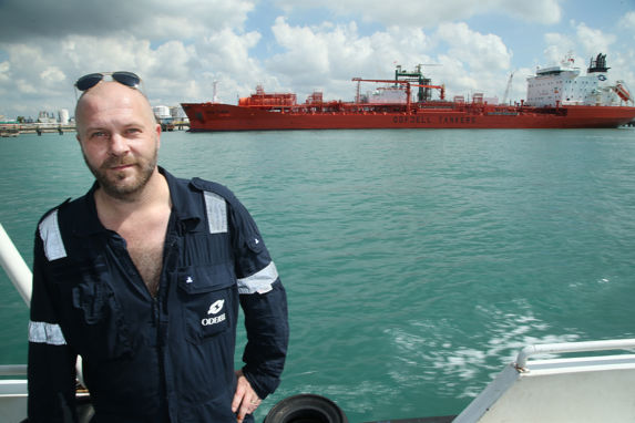 port captain odd arne hansen i singapore, med det røde tankskipet bow flora i bakgrunnen